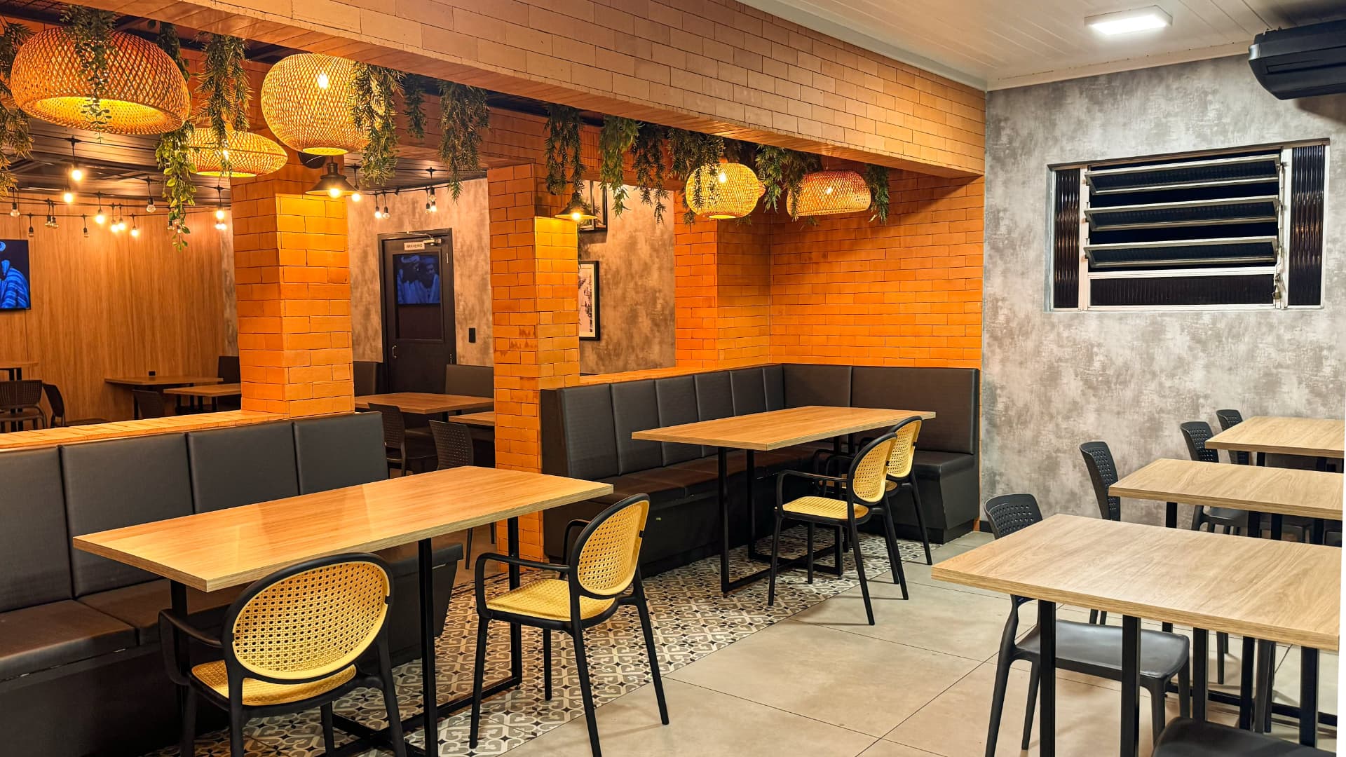 Salão com tijolos e luminárias do Restaurante Plaza em Araranguá