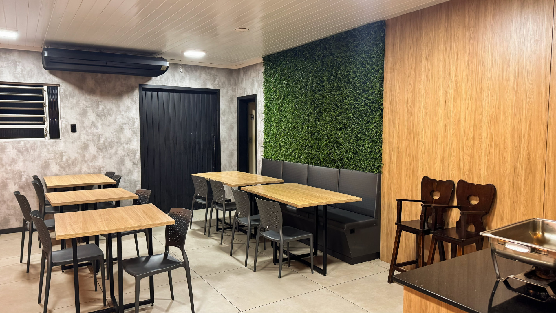 Salão com parede verde do Restaurante Plaza em Araranguá